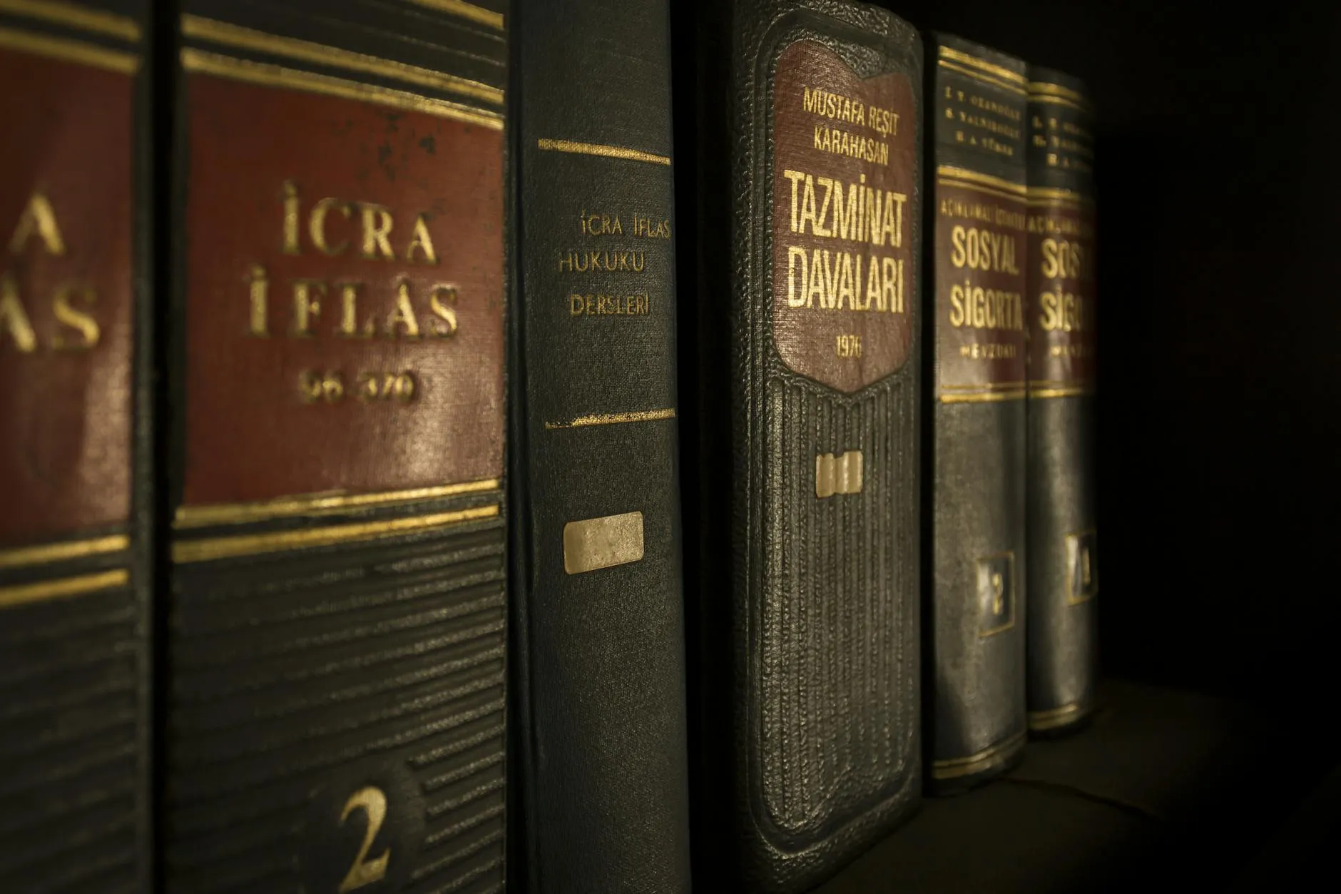 Close-up of leather-bound law and regulation books on a shelf, representing a small law firm library used for social media content research